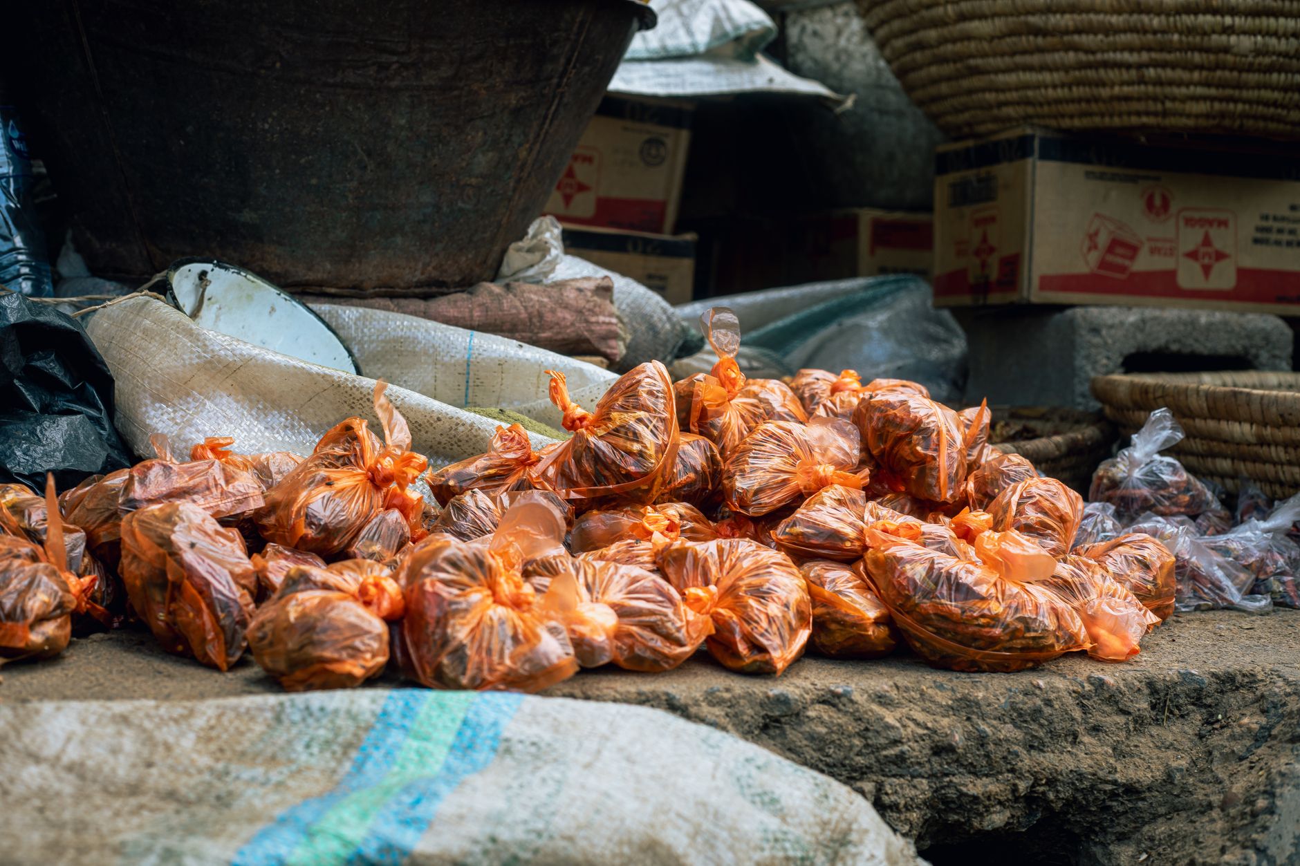 Workers handling seasoning packages on a food production floor.