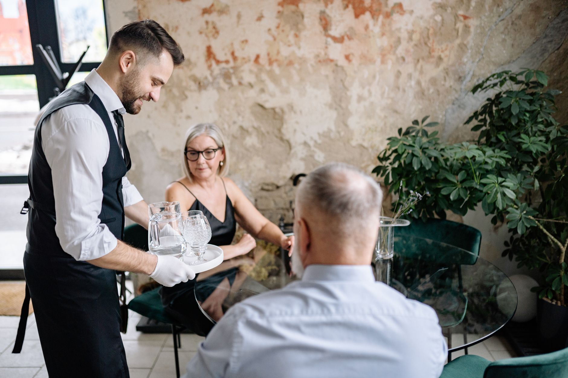 Server carrying plates to tables while guests dine