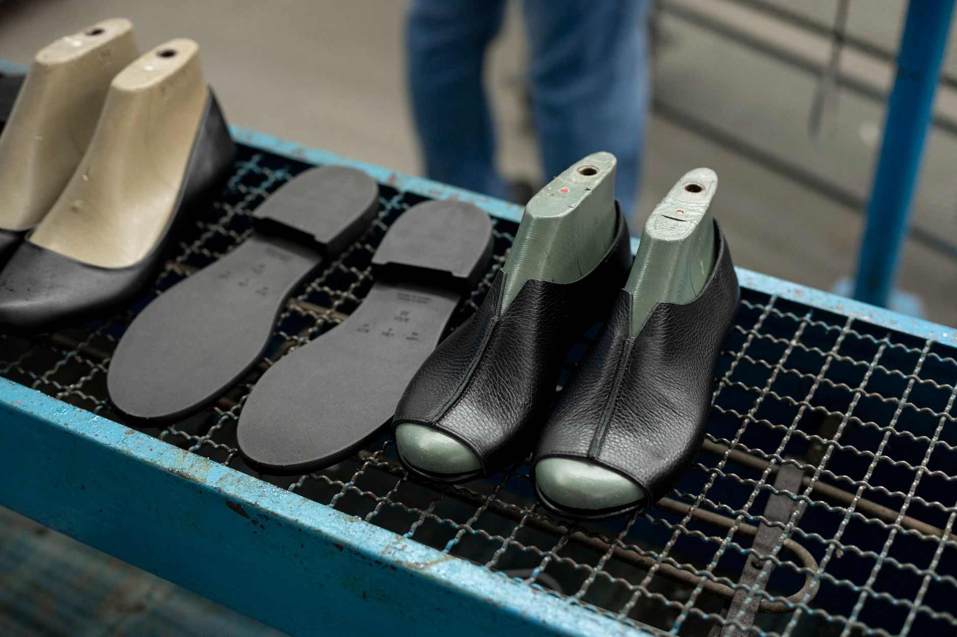 A footwear production area where automated sole gluing replaces inconsistent manual spray.