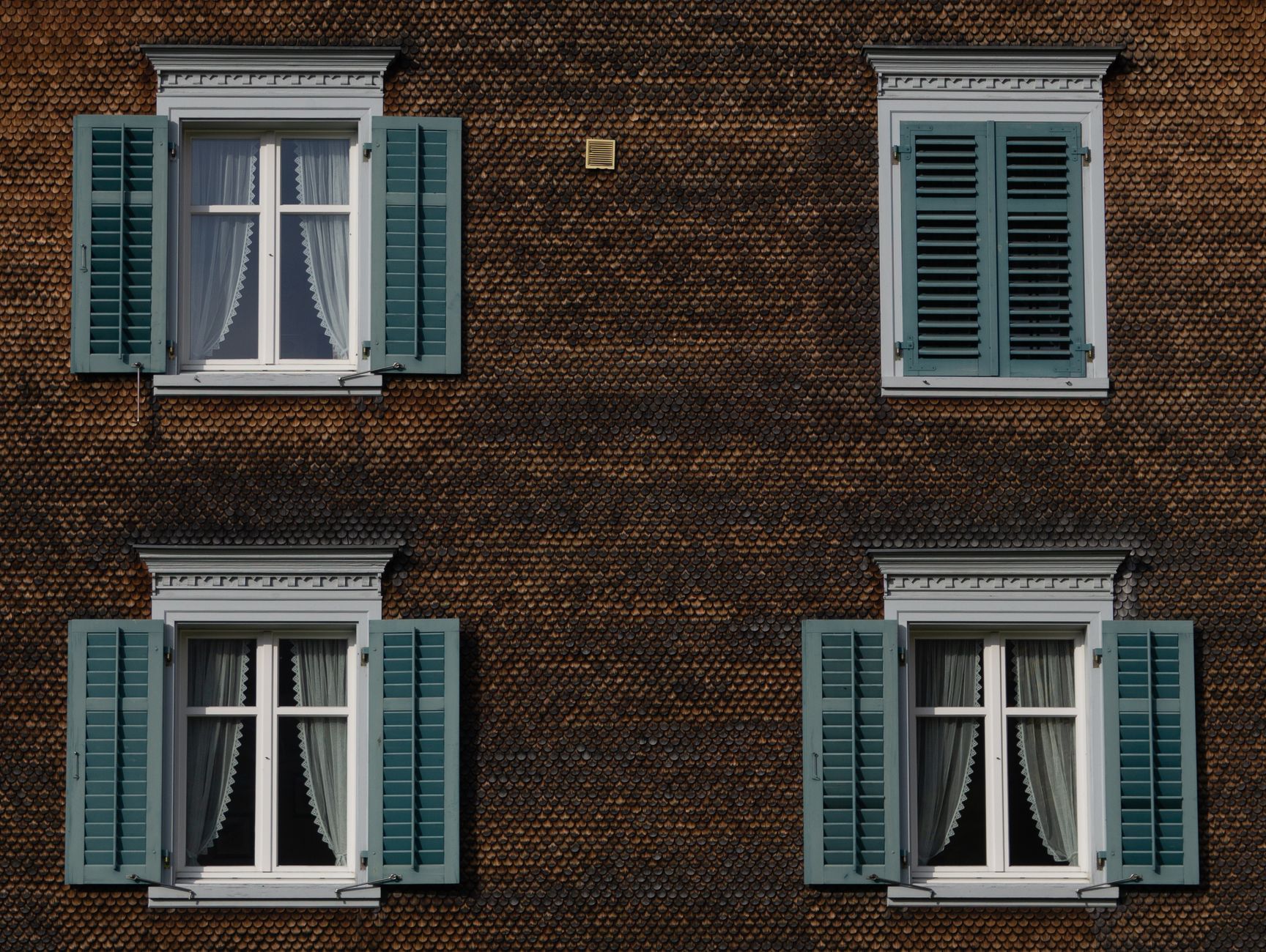 Stacked wooden shutter panels lined up in a bright finishing area.