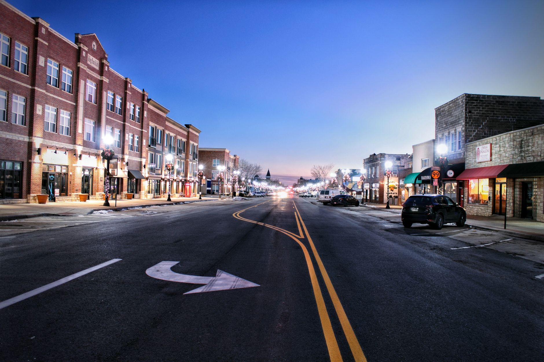A small-town commercial street, echoing the rural labor market that pushed this grocer toward scheduled robot floor care.
