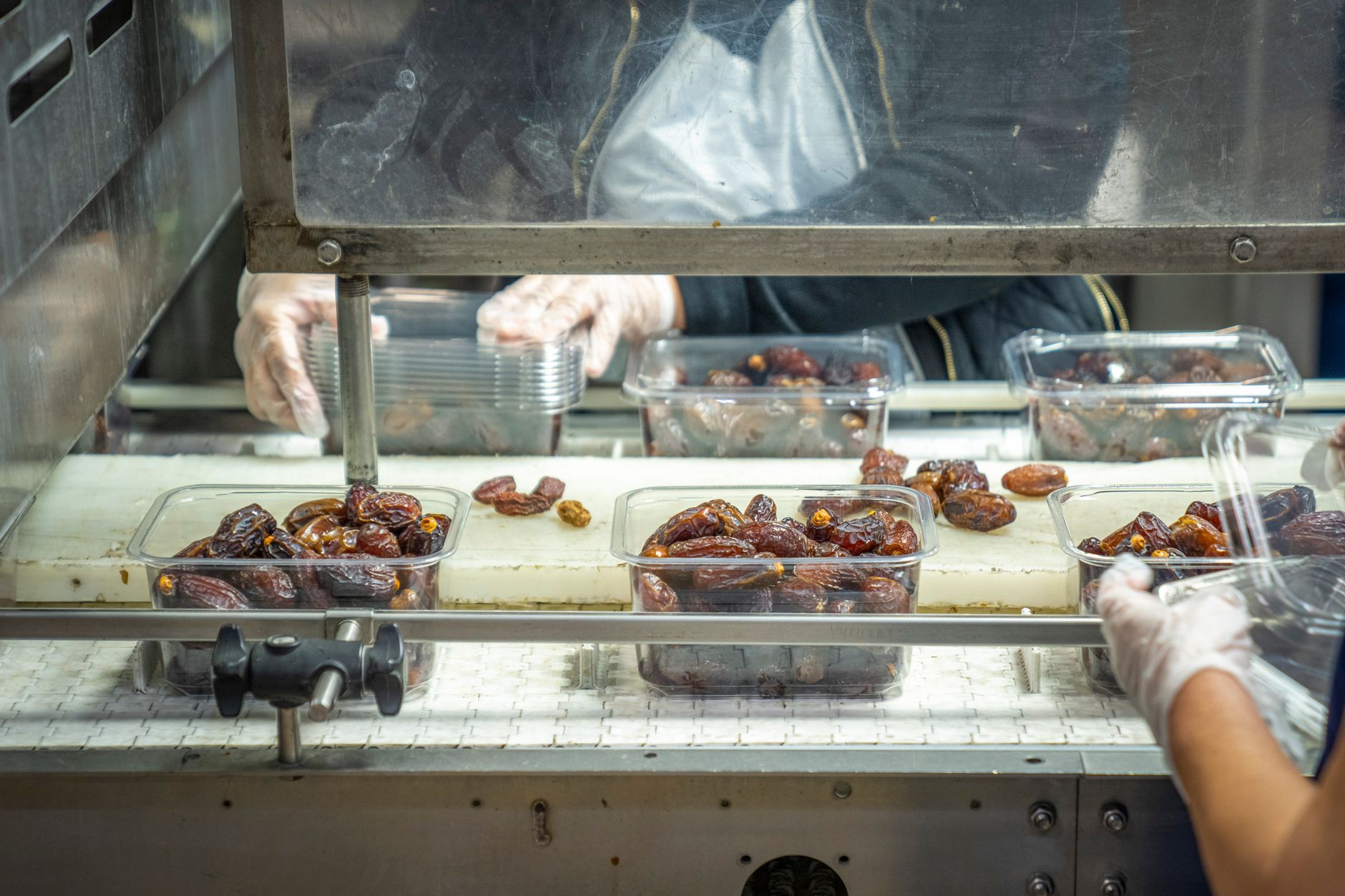 Workers monitor a snack food packaging line in a manufacturing plant