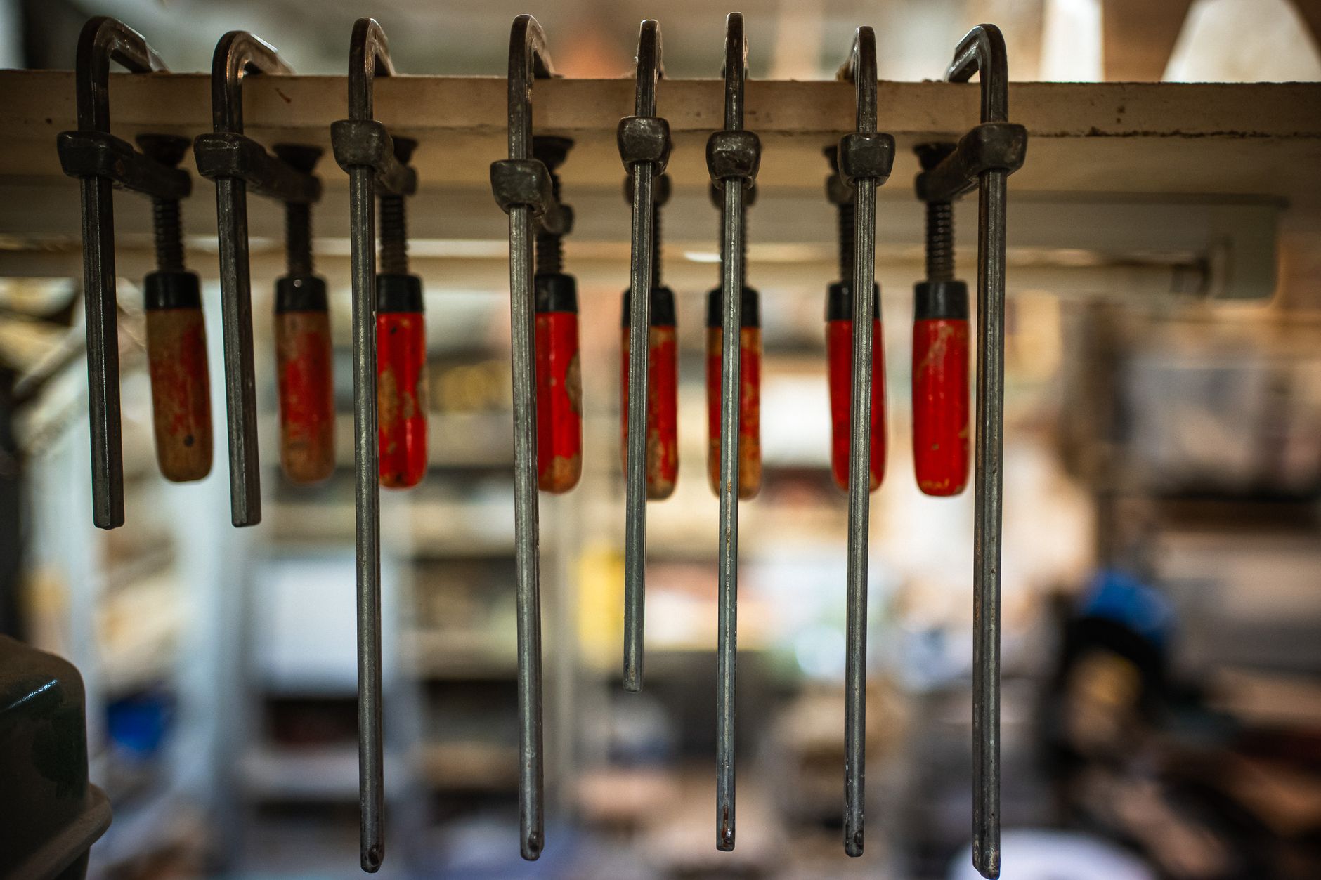 Small metal clamps and fixtures rest on a fabrication workbench between production runs.