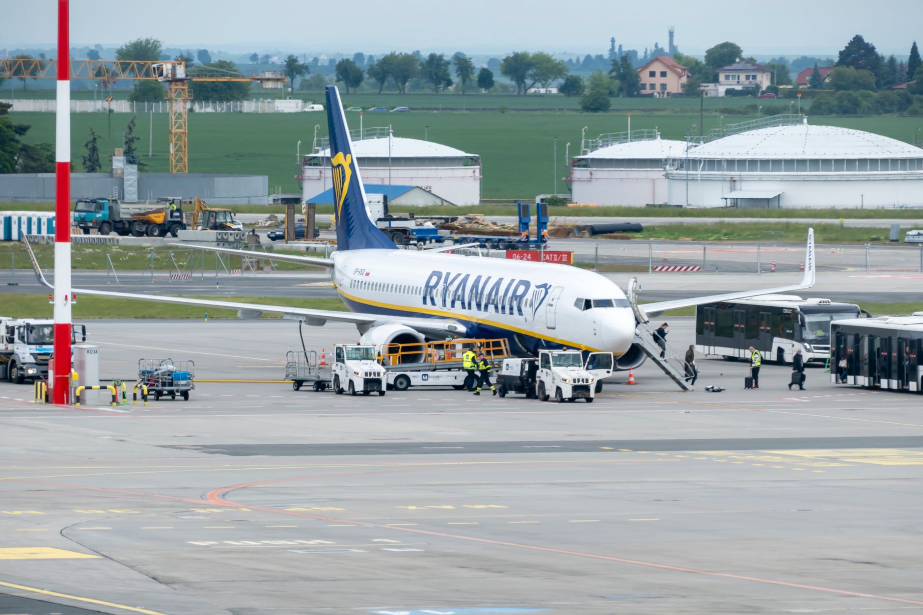 A commercial aircraft parked on the ramp outside a maintenance hangar.