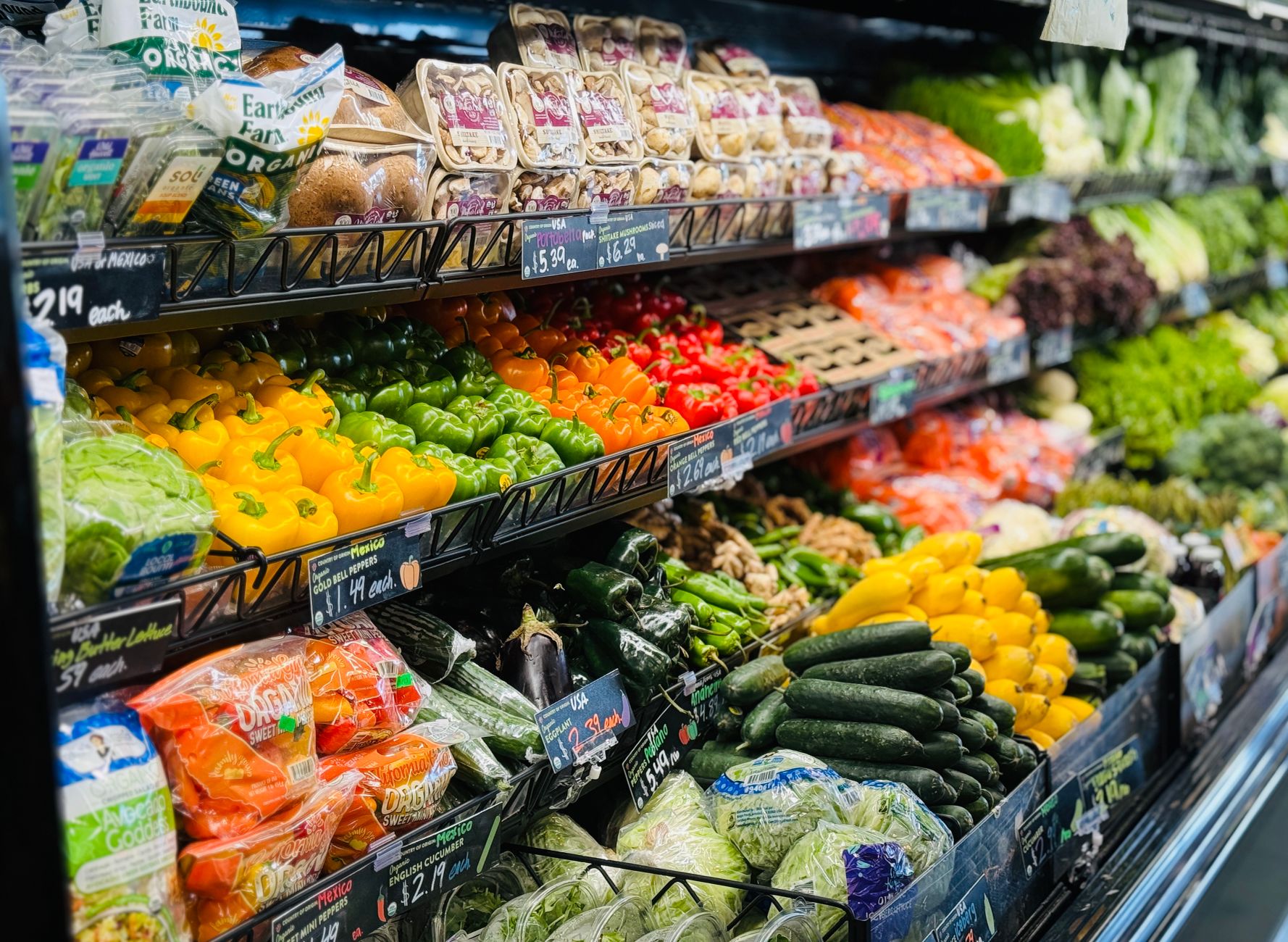 Colorful produce displays along a grocery aisle where spills and debris make consistent floor care important.