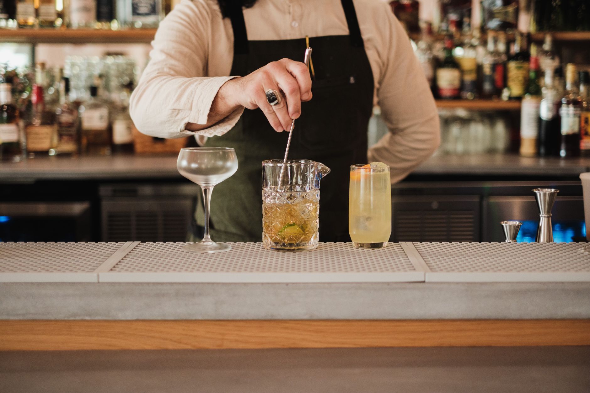 A bartender prepares cocktails during a busy live-service shift.