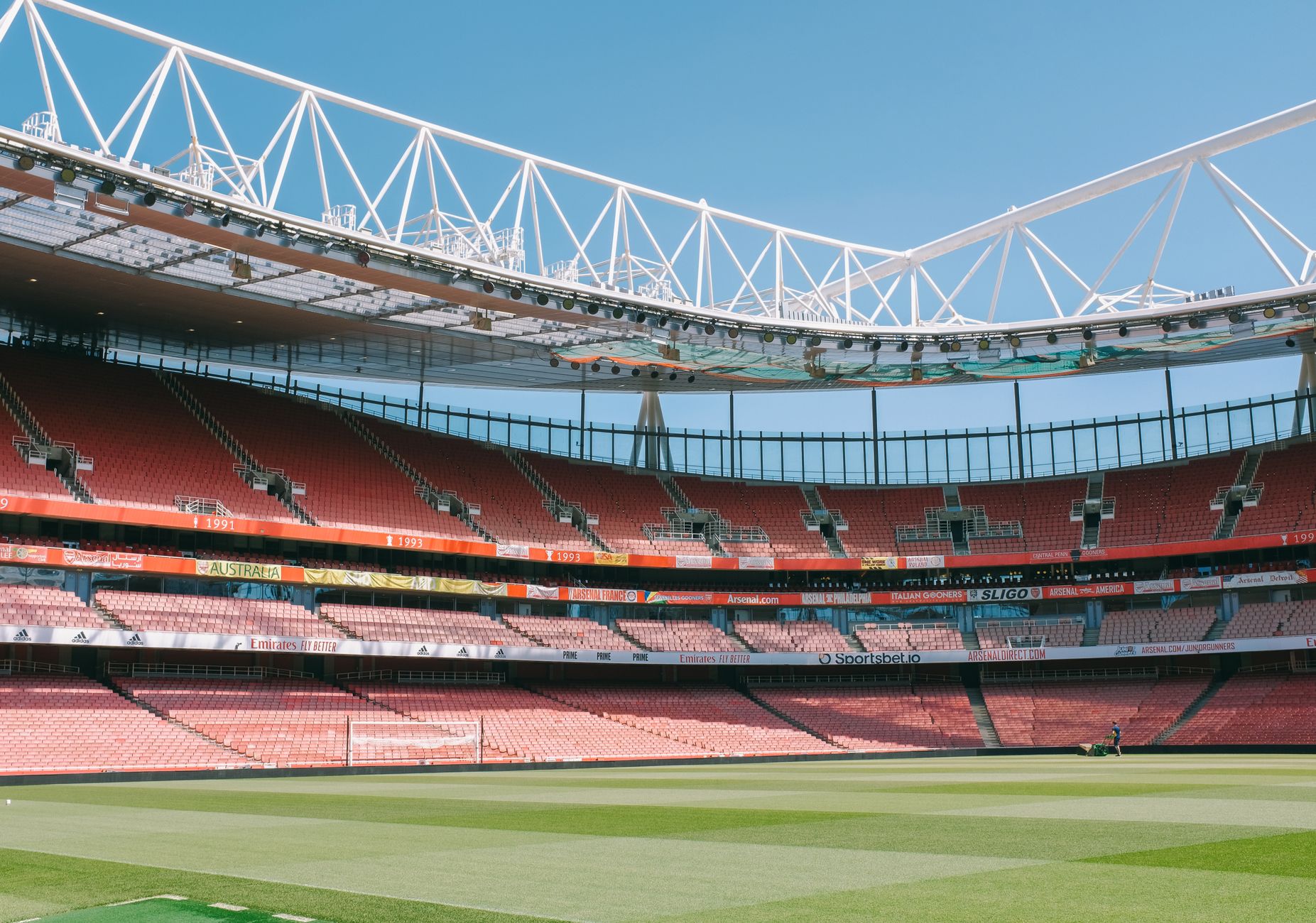 A large London football stadium illuminated before an event, establishing the scale of the venue's cleaning operation.