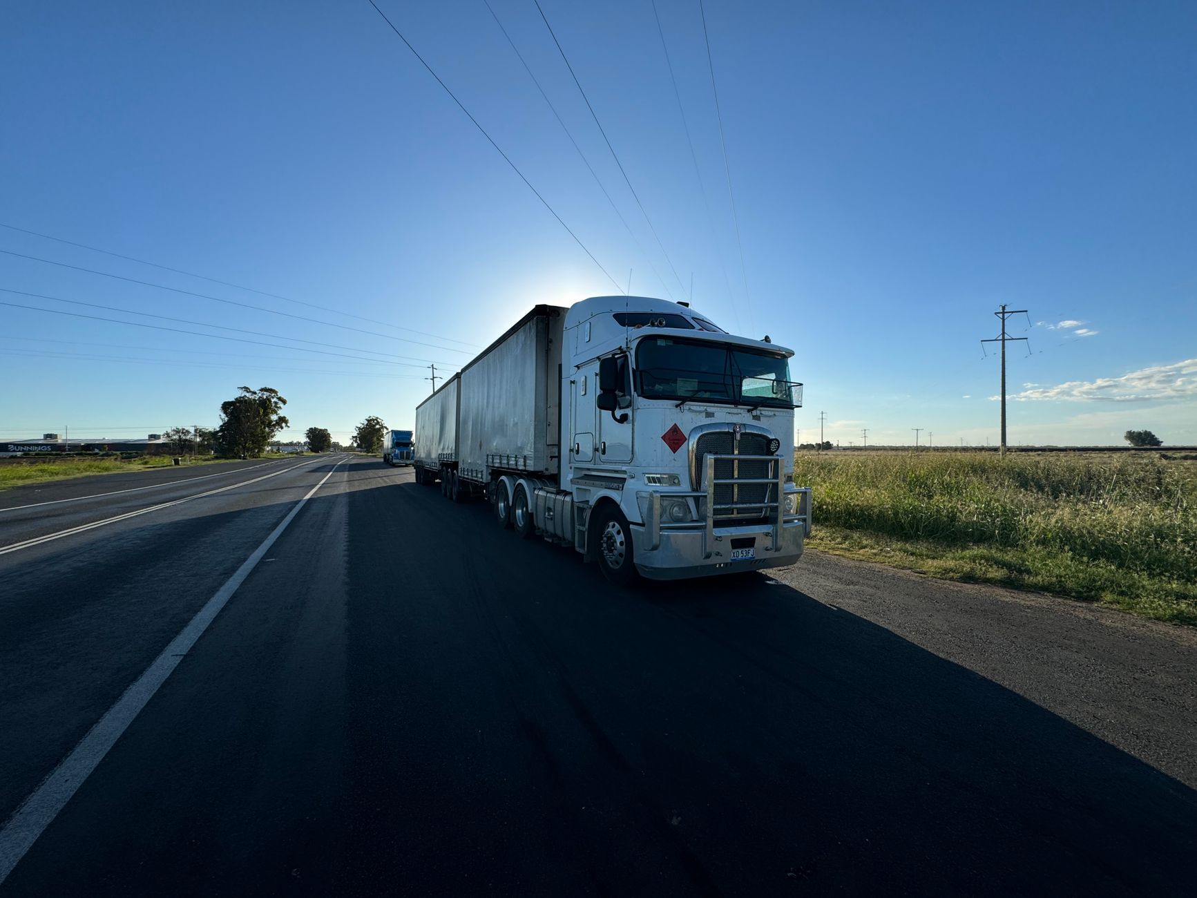 Freight truck on a highway near industrial buildings
