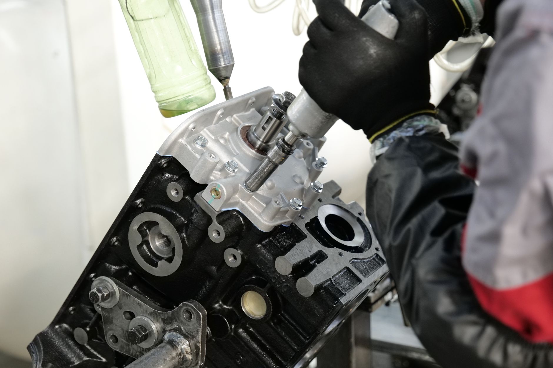 Workers and equipment occupy a large automotive components factory floor.