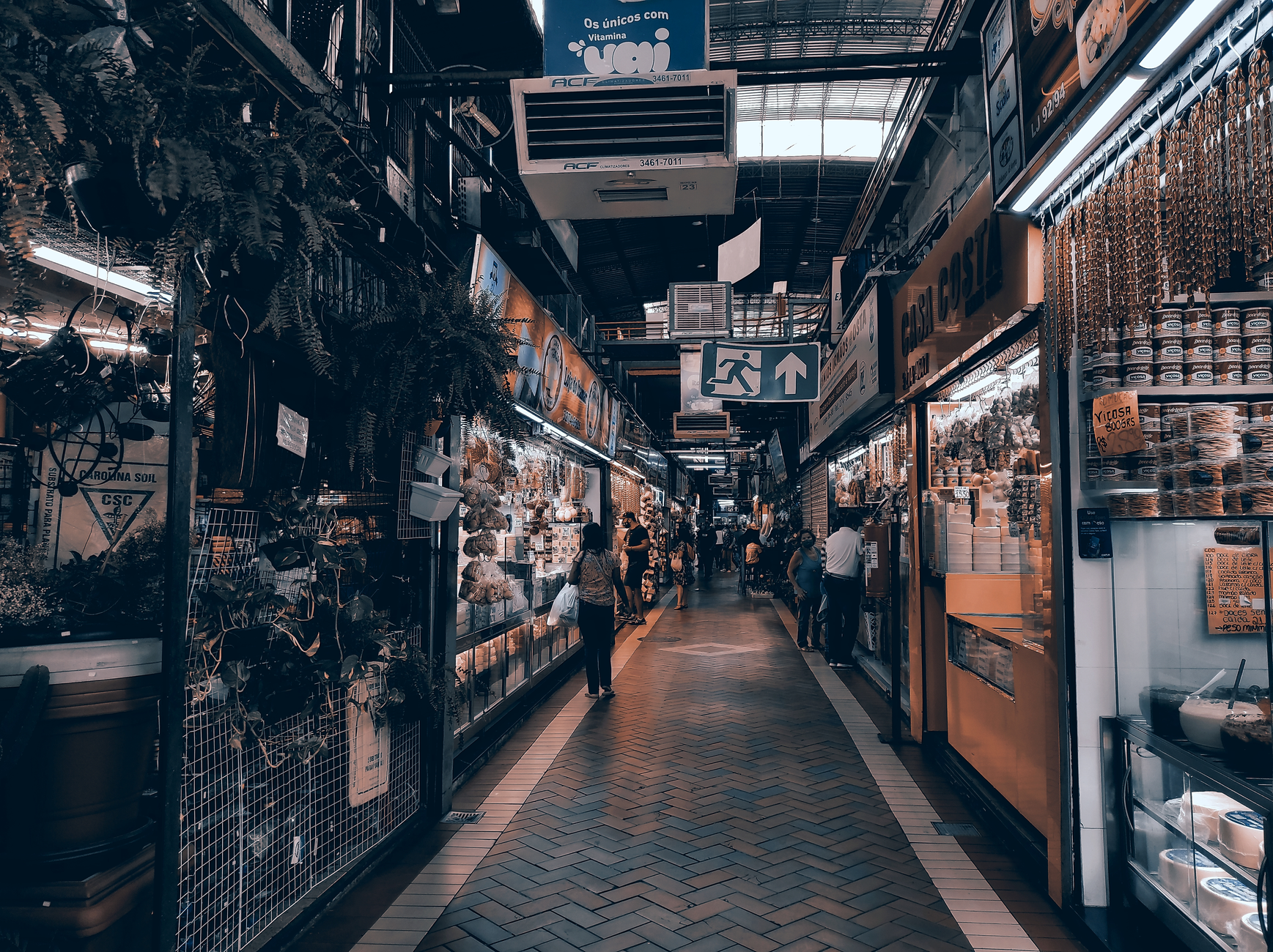 A narrow restaurant aisle winds between closely spaced dining tables.