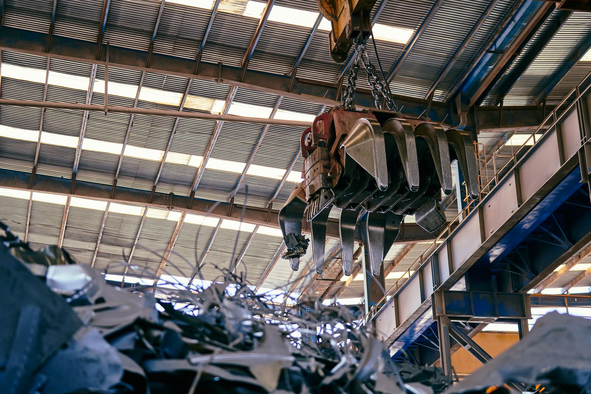 Wide view of a busy recycling facility interior with conveyors and sorted materials, illustrating a high-throughput Bay Area MRF retrofit.