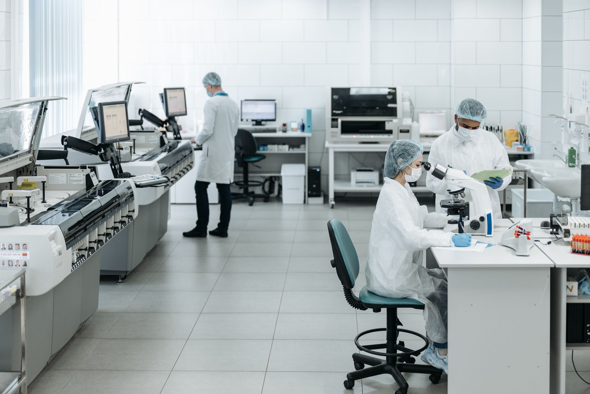 Clinical laboratory staff work together in a modern hospital testing environment.