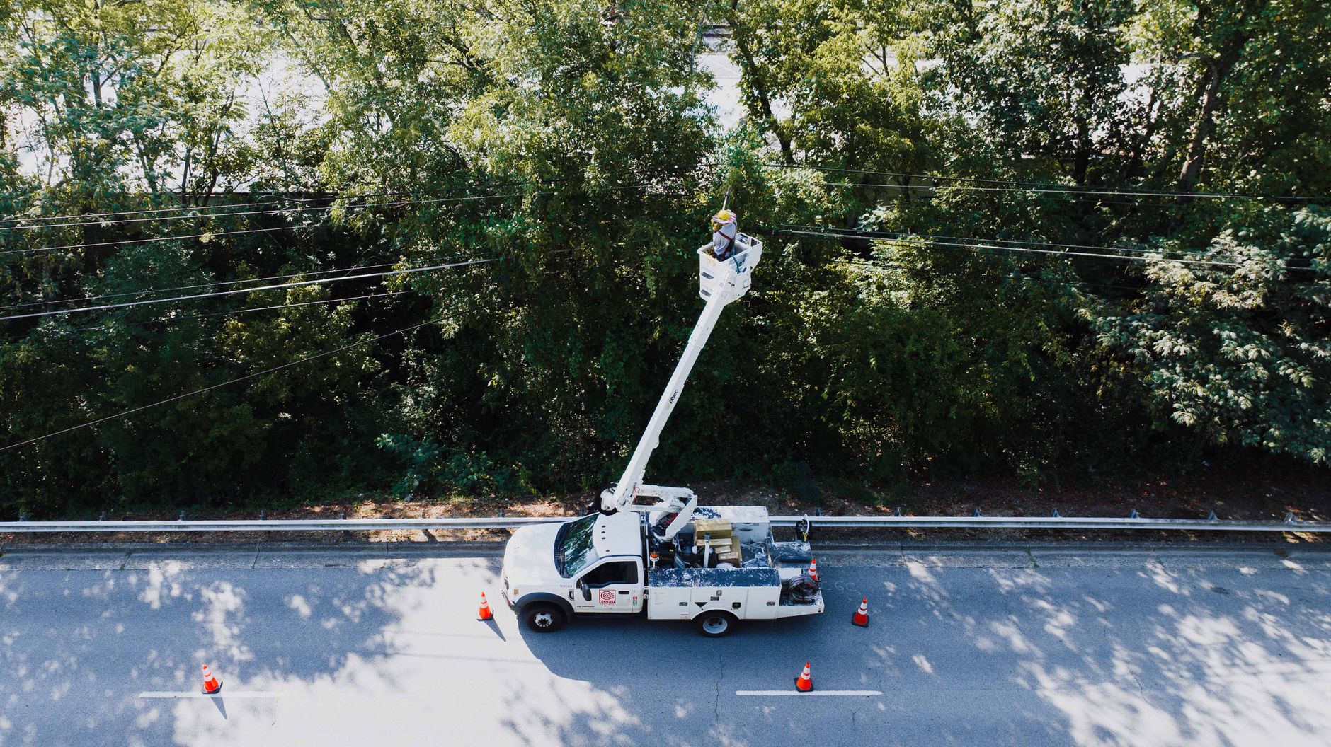 A utility bucket truck parked at a pole, representing the legacy inspection method the drone program replaced.