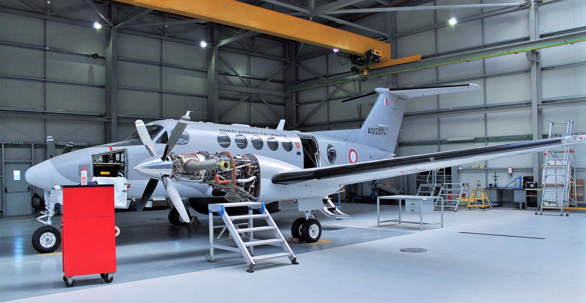 A technician works with precision aircraft components in an aerospace manufacturing workshop.