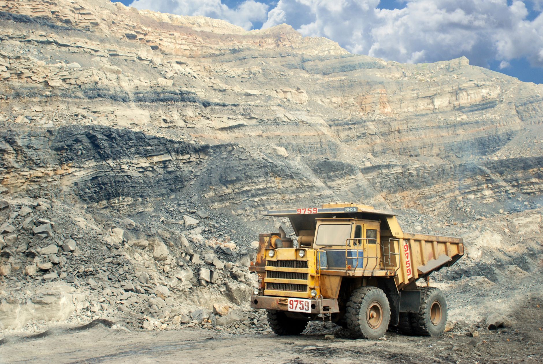 Terraced benches stretch across a large open-pit coal mine in Australia.