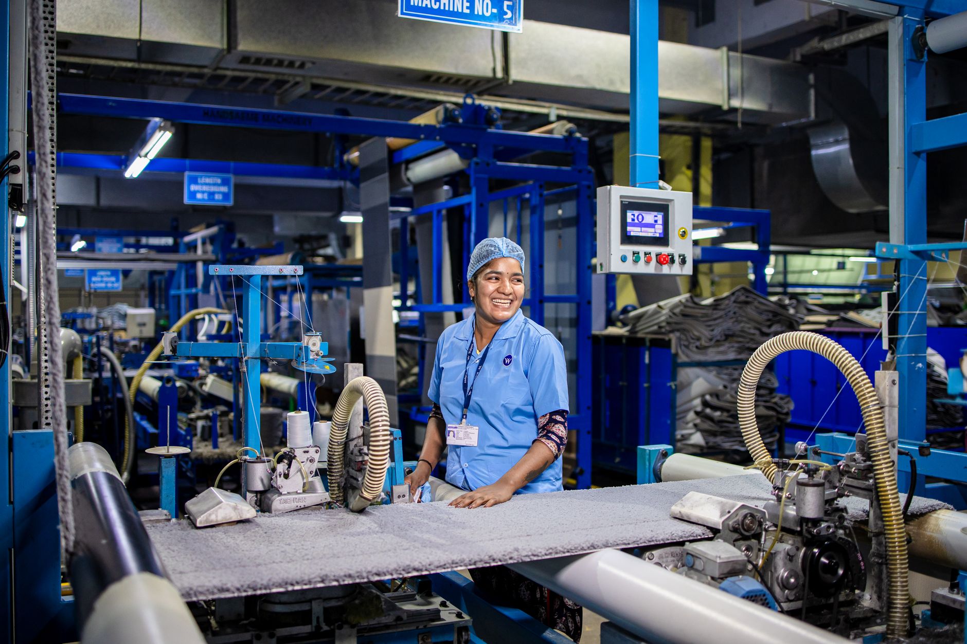 A production worker carries components along an assembly area