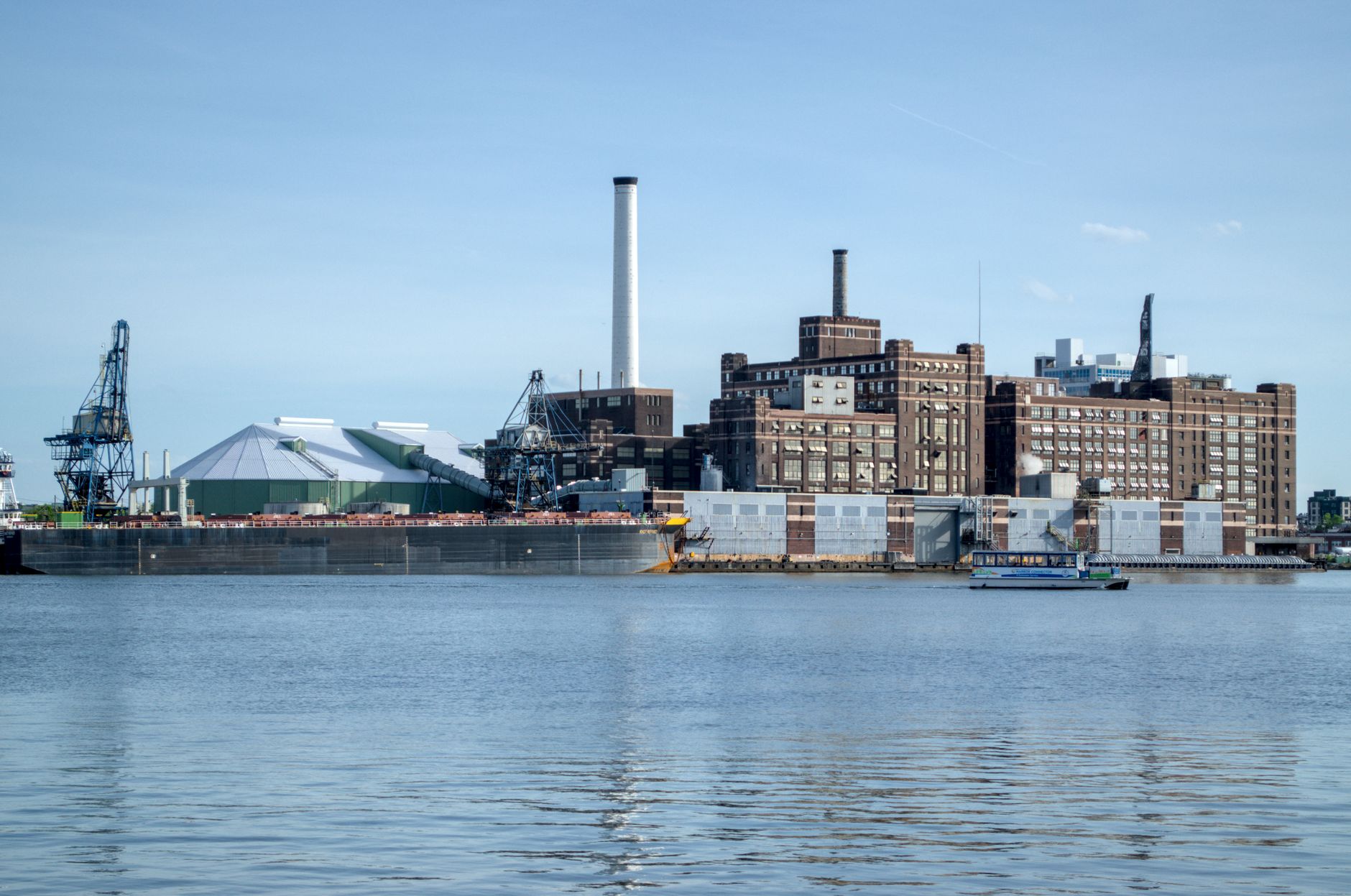 Interior view toward a plant shipping dock with trailers visible beyond bay doors.