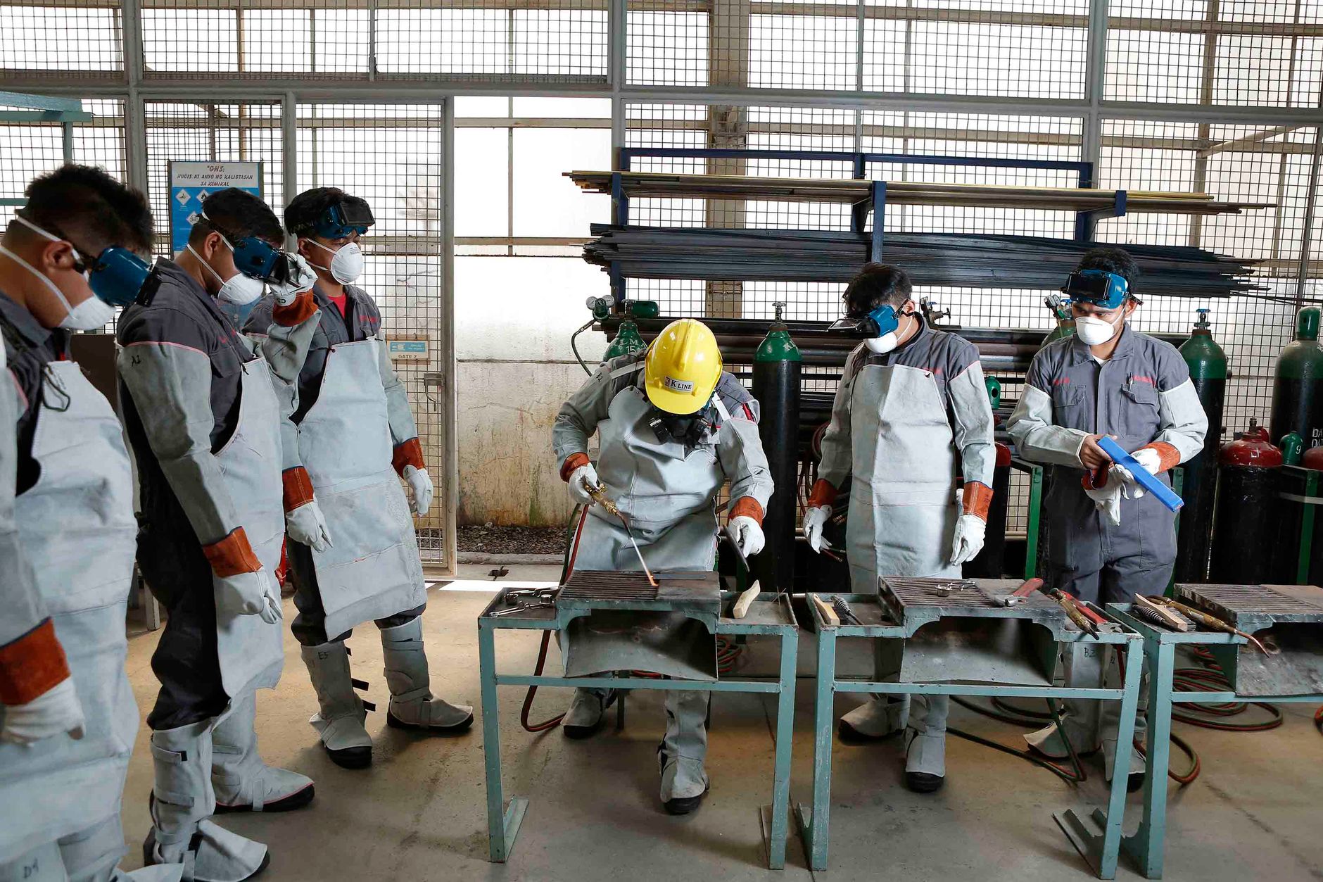 A small group of factory staff stands in a production-area training session, matching the article’s short operator ramp-up and phased rollout.