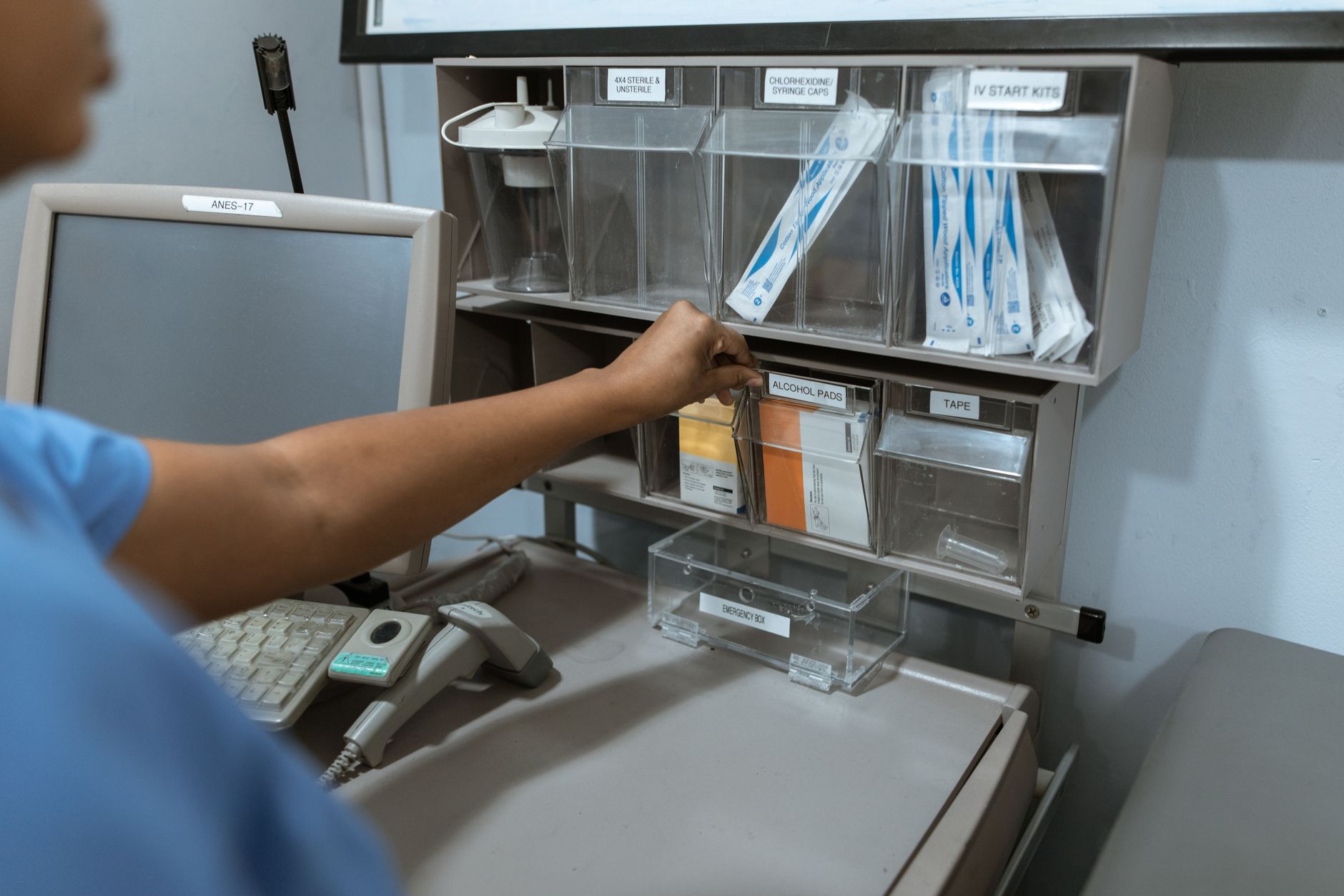 Clinical staff at a hospital nursing station coordinating patient care away from the hallway.