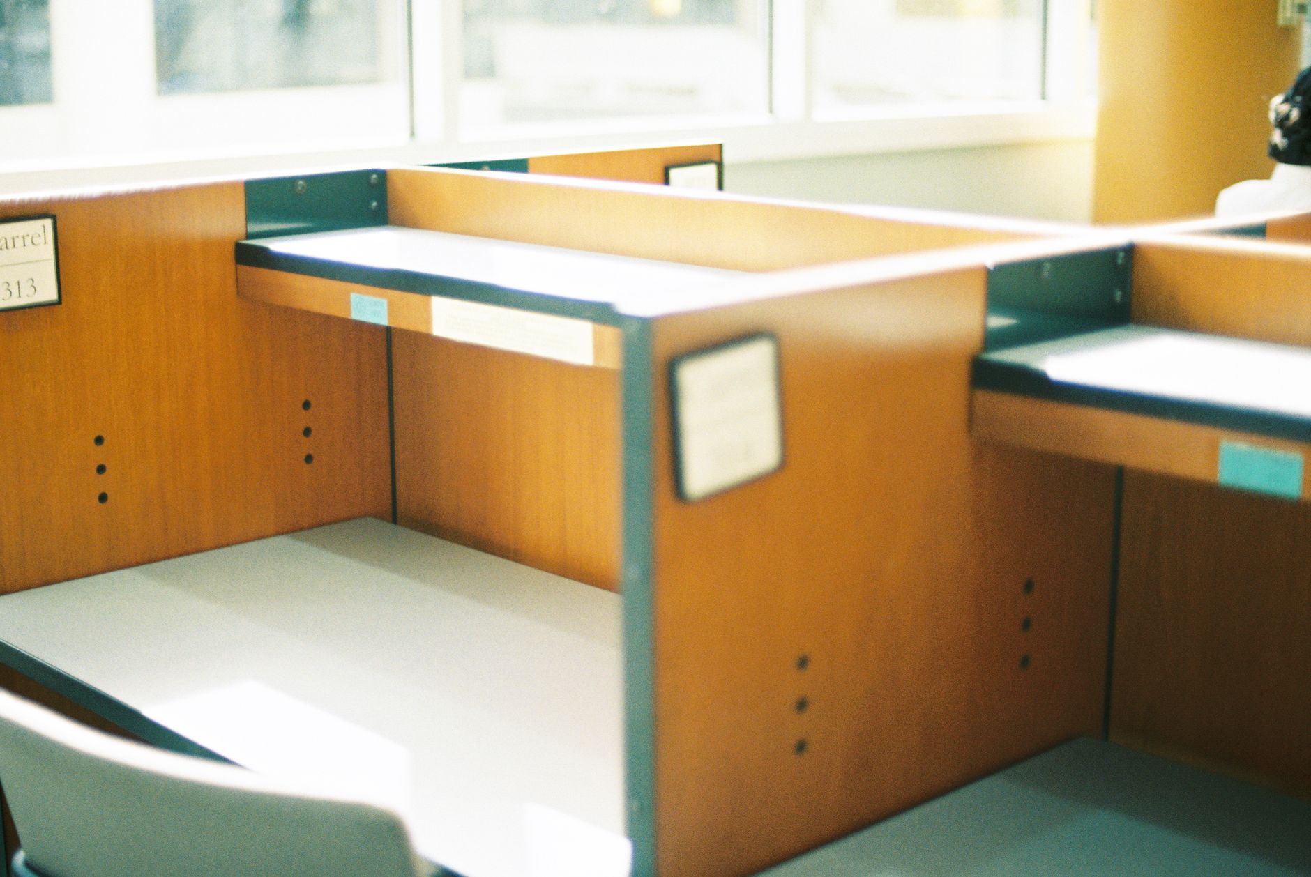 Rows of cubicles in an open office floor where autonomous vacuums handle long carpet runs.