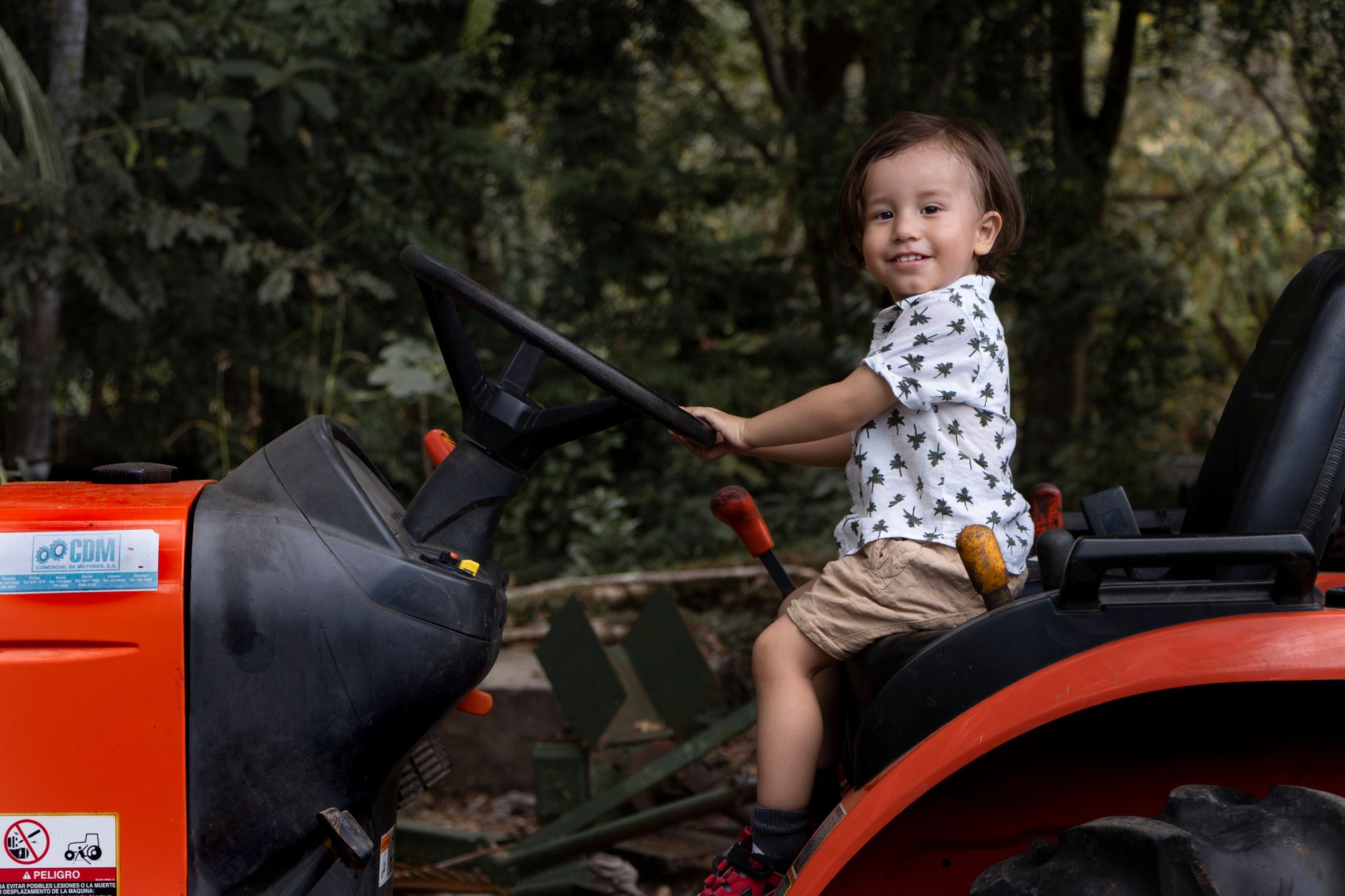 A farm operator at the steering wheel inside a tractor cab during fieldwork.