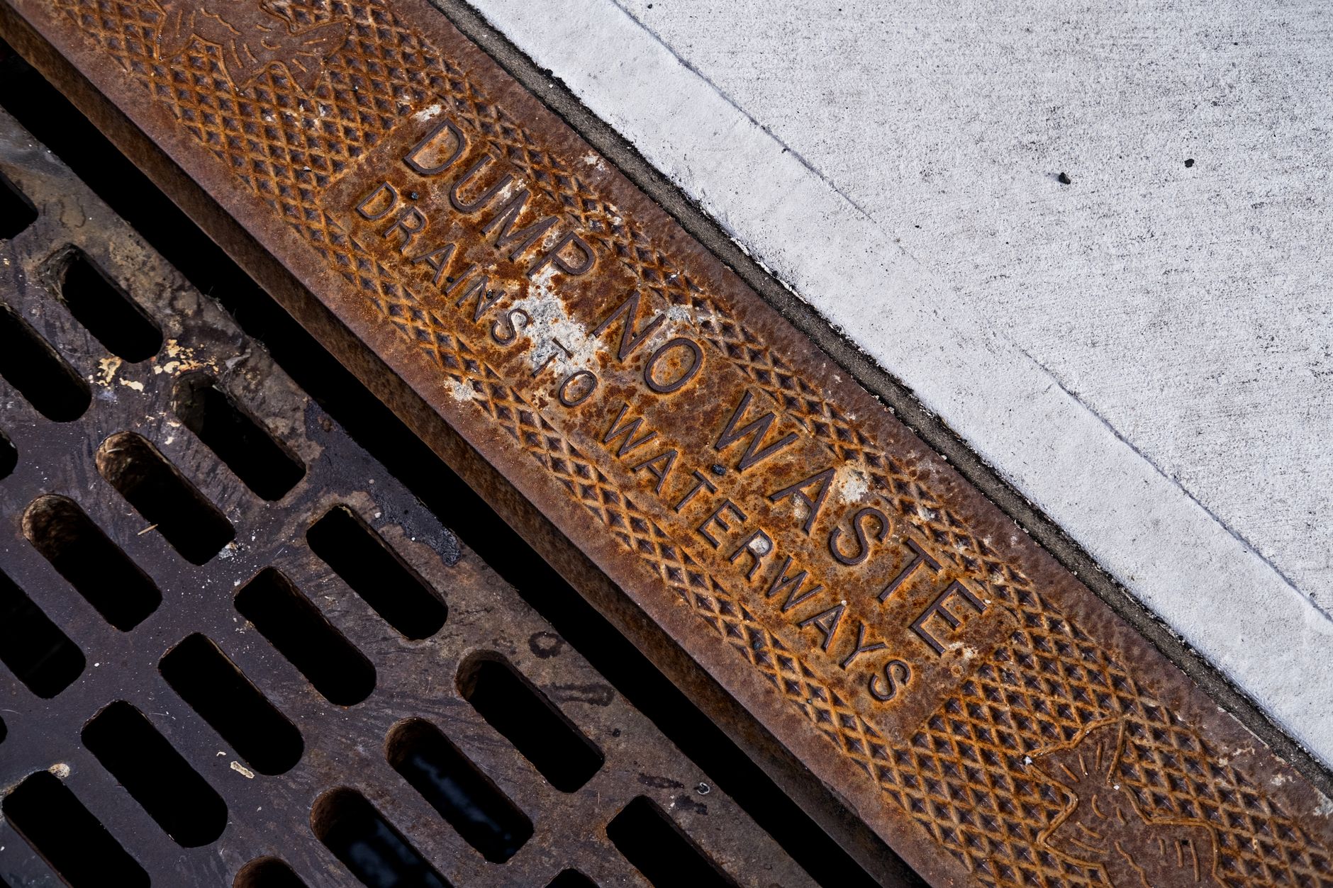 A street drain or manhole access point representing how utility crews reach buried sewer assets before inspection and cleaning work begins.
