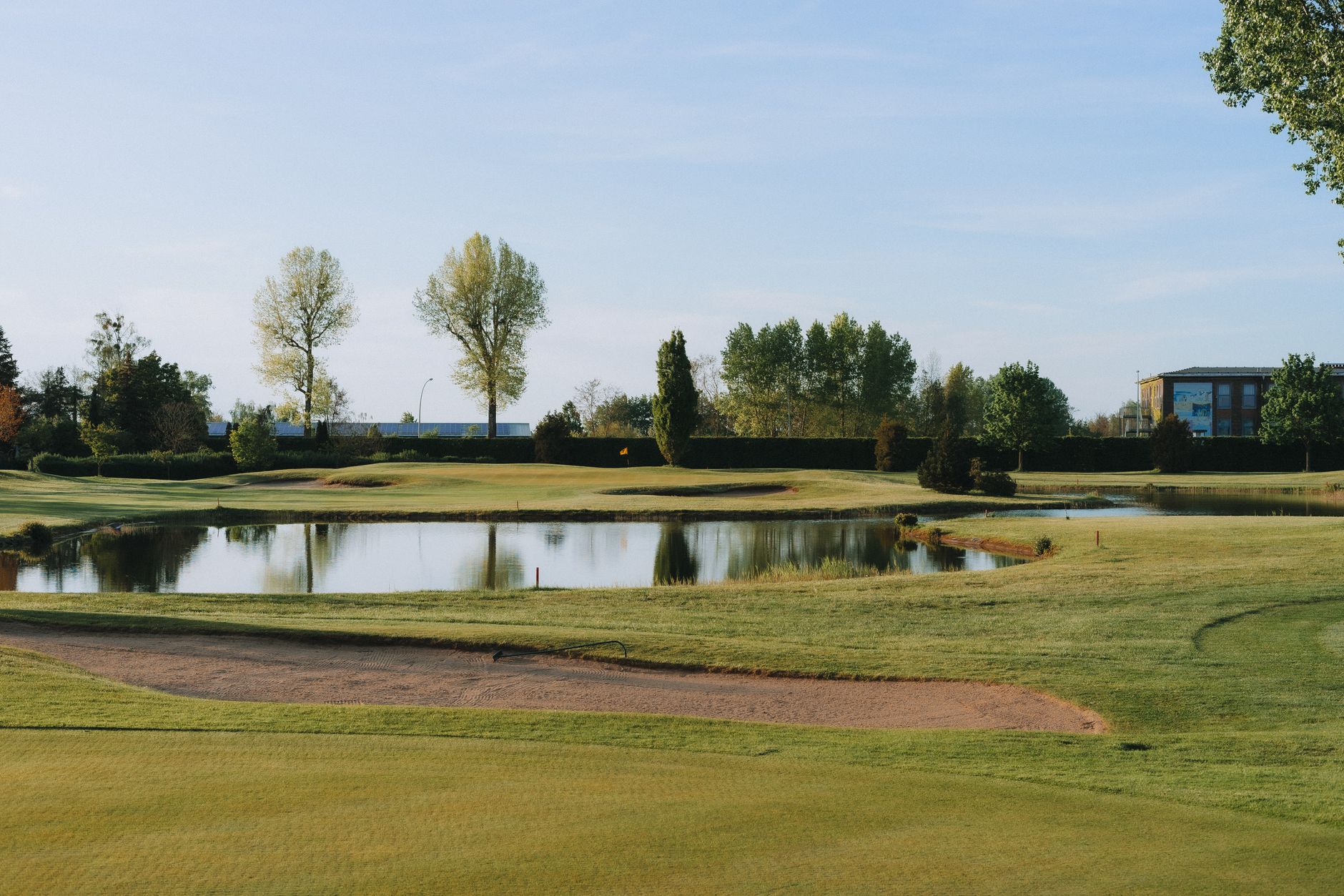 Beautiful summer day at a golf course with a peaceful pond and lush greenery