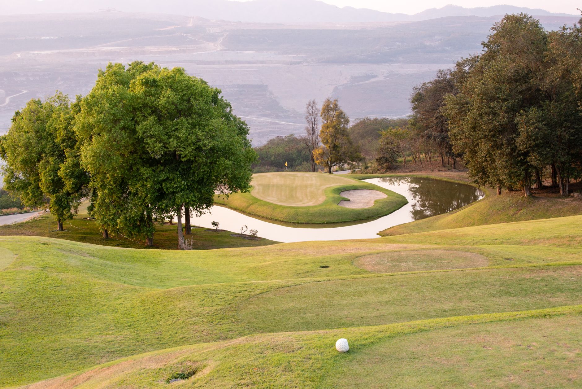 Stunning golf course landscape with a pond, perfect for a summer day of golfing