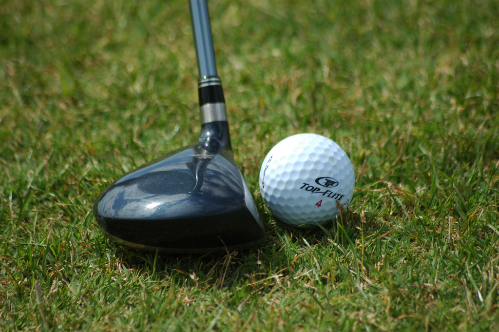 Golf ball resting near fairway wood