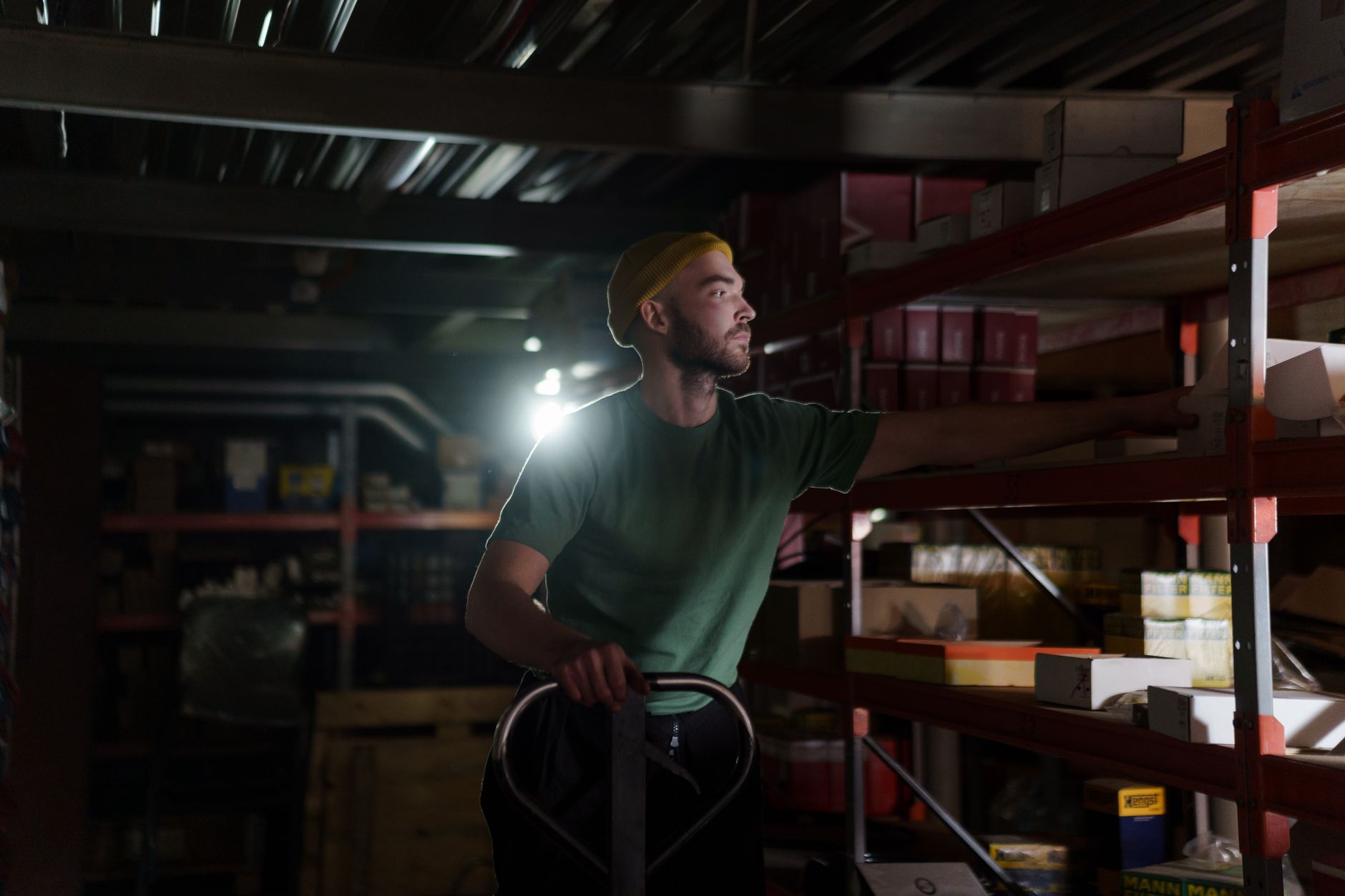 Warehouse staff in work clothing moving goods along a packing area during a shift.
