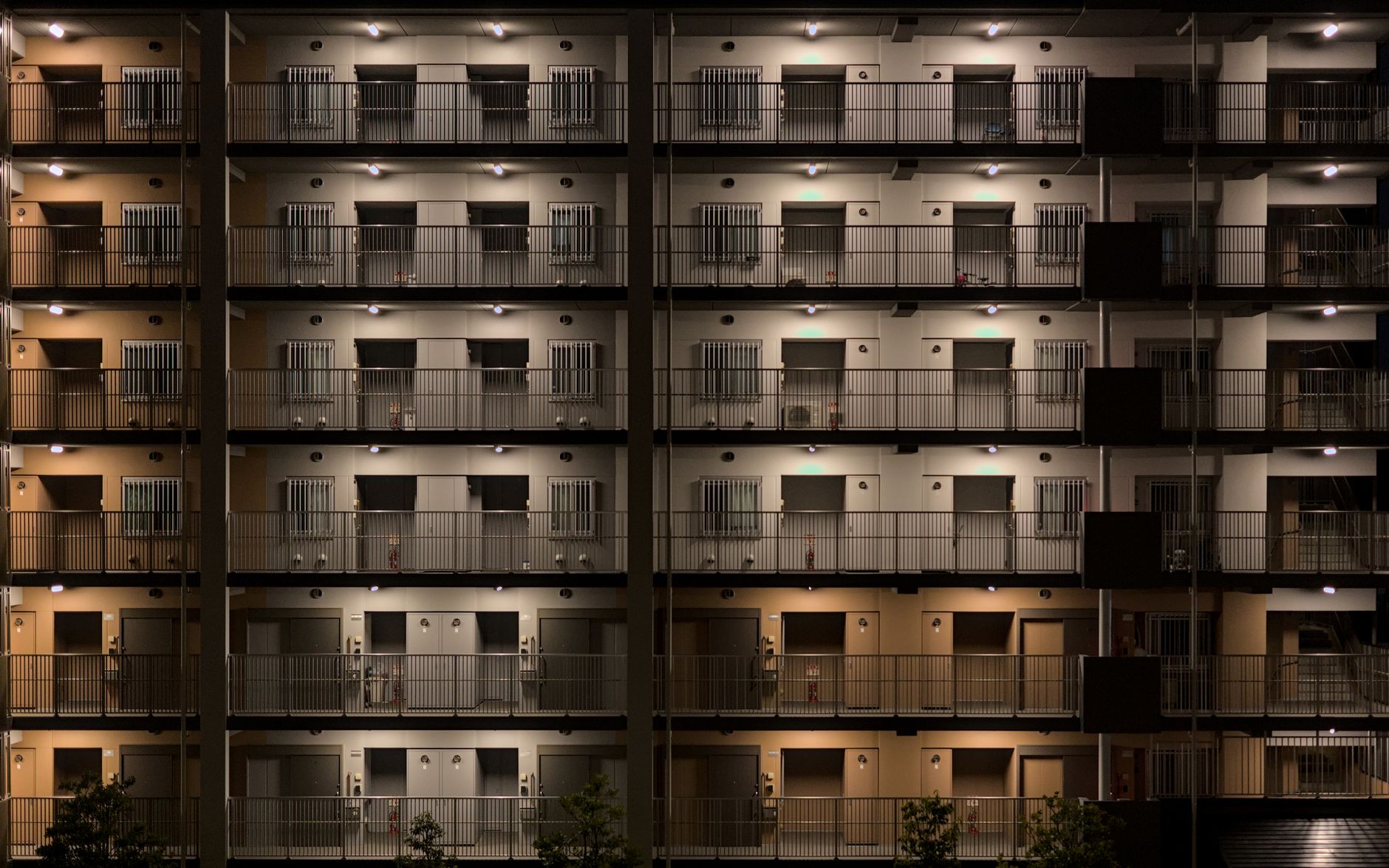 An apartment complex and its parking area illuminated at night, representing the property’s after-hours security needs.