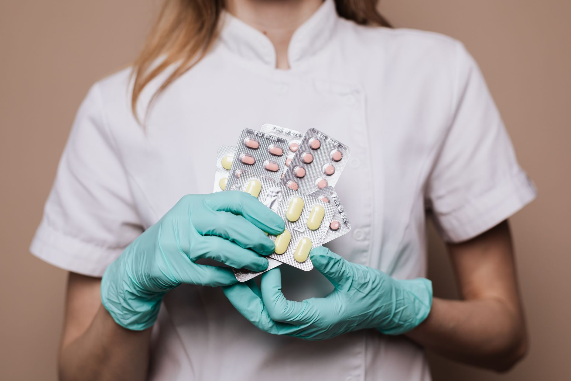 A pharmacy worker prepares prescription medication for home delivery at a clinical pharmacy counter.