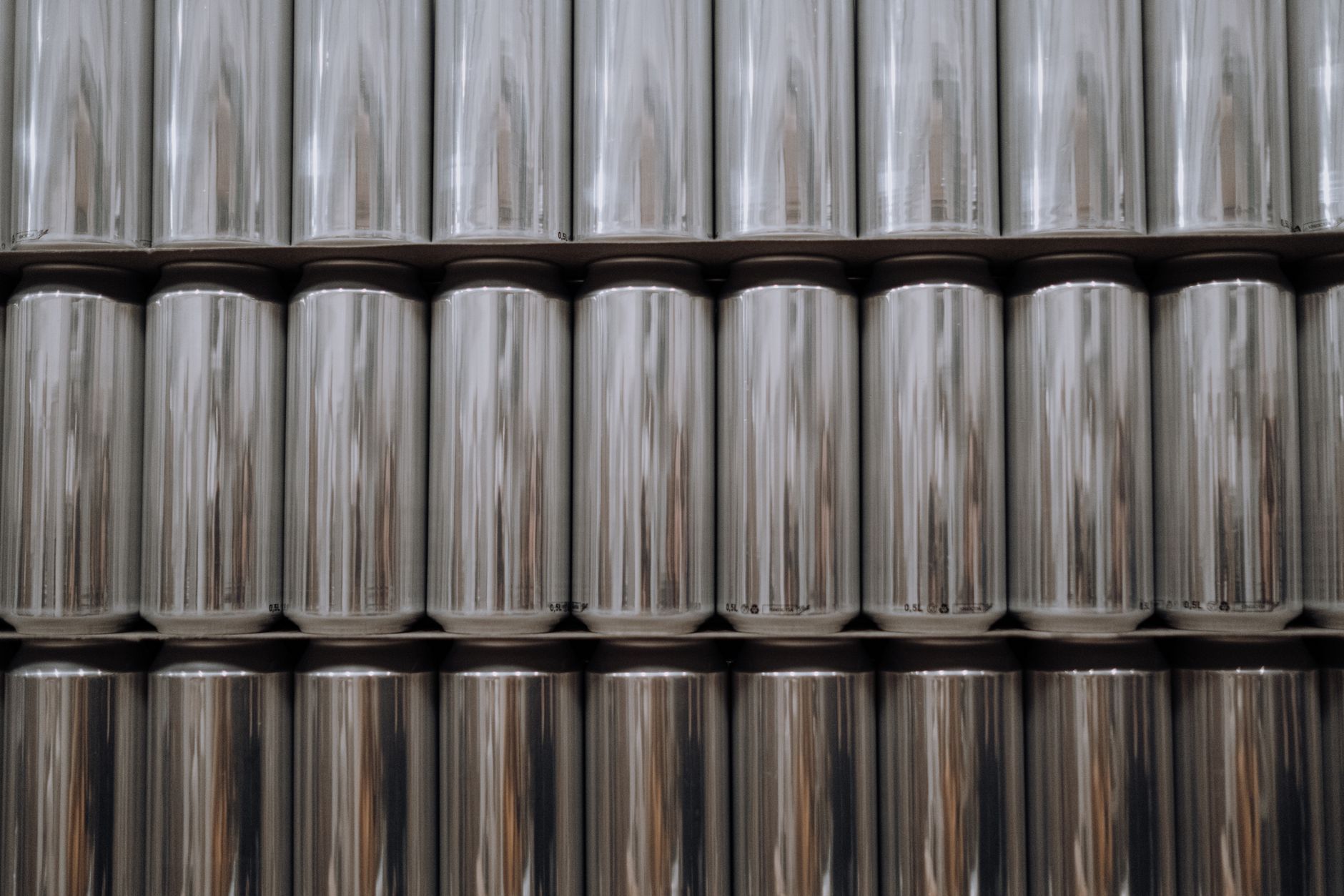 Stacked cylindrical aluminum billets sitting in a plant storage area.