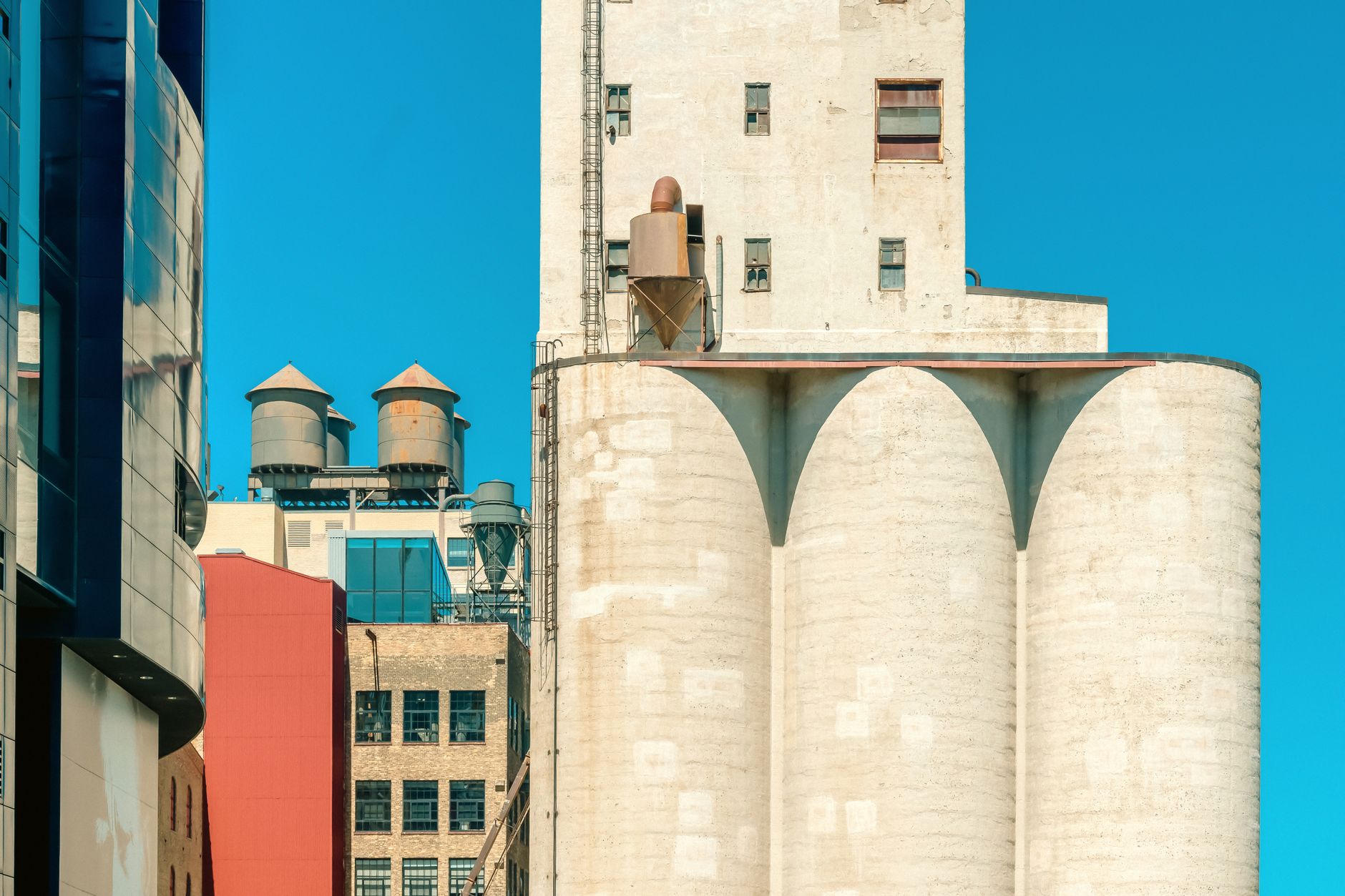 Interior of a grain mill warehouse with stacked sacks and pallets on a concrete floor.