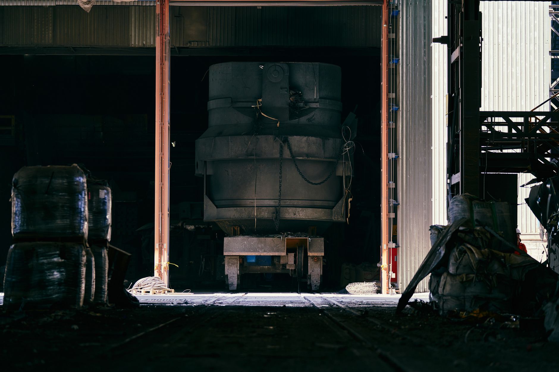 The interior of a large heavy-industry plant with high ceilings, steel structures and a long working floor.